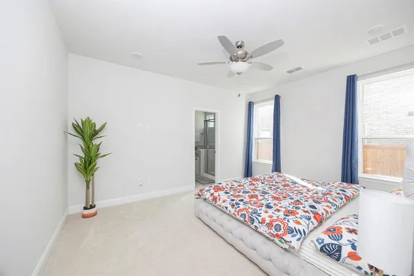 a bedroom with a large bed and a chandelier