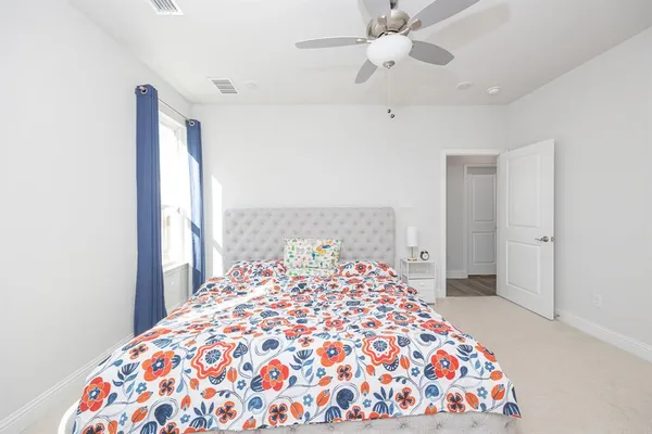 a bedroom with a large bed and a chandelier
