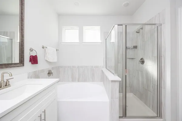 a bathroom with a tub sink and mirror