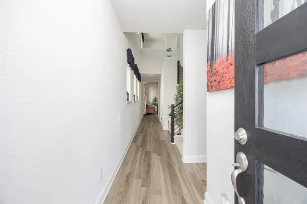 a view of a hallway with wooden floor and staircase