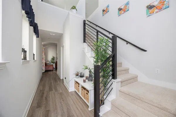 a view of a hallway with wooden floor and staircase