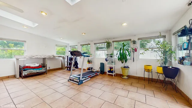 a spacious bedroom with a bed a dresser and wooden floor