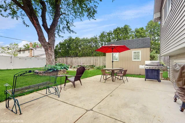 a view of an house with backyard space and a tree