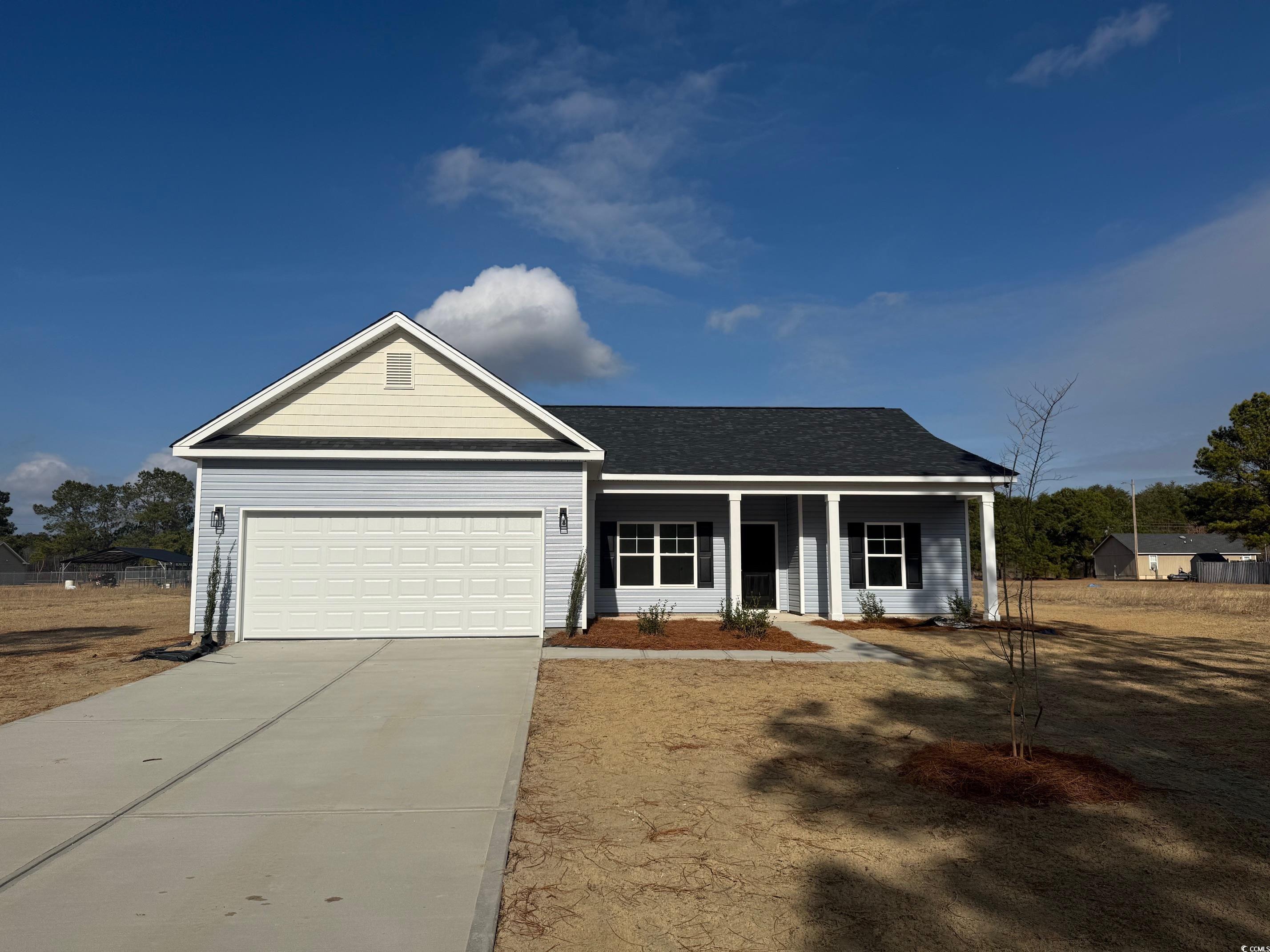 View of front of house featuring covered porch, driveway, an attached garage, and a shingled roof