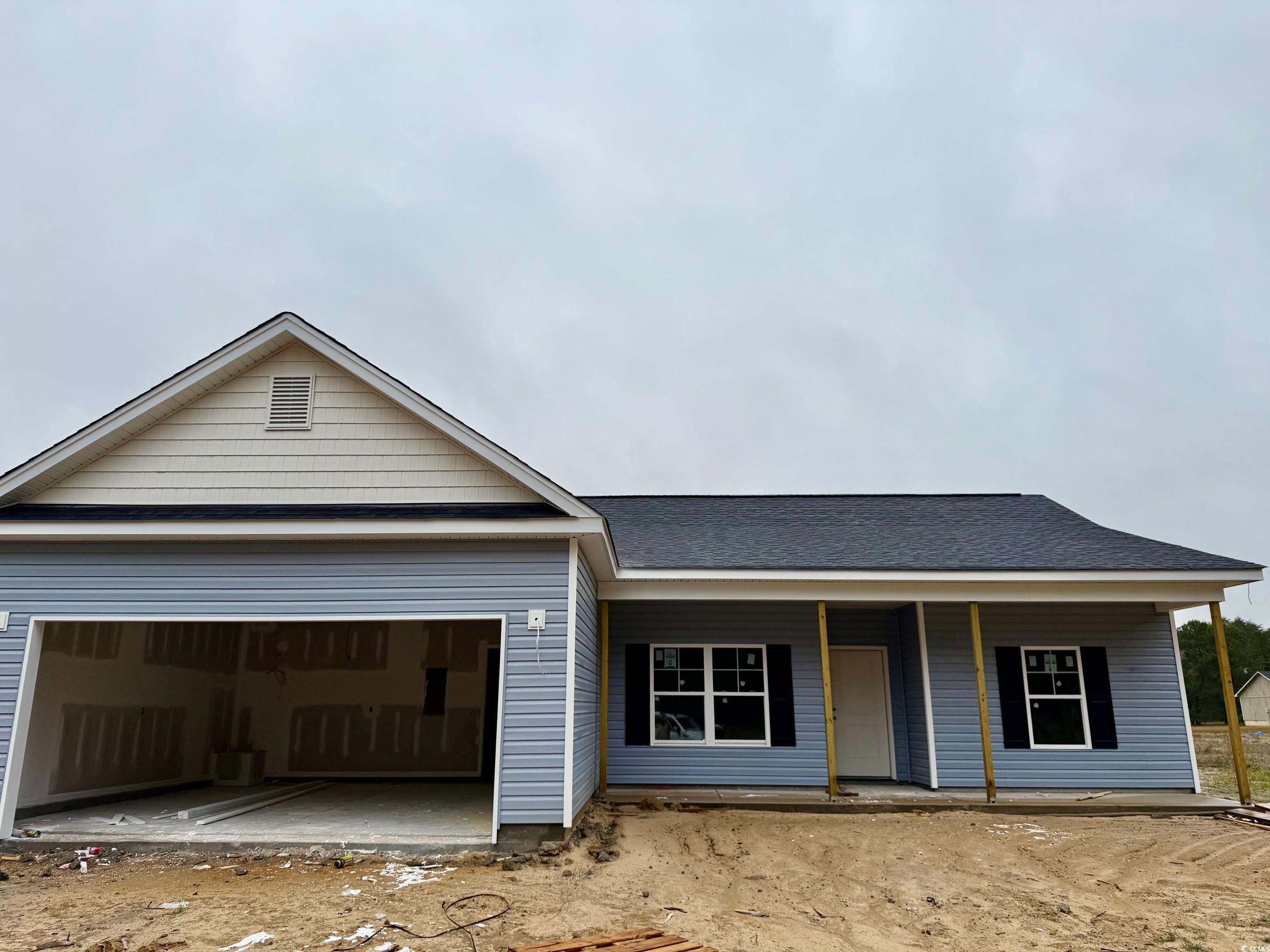 View of front facade featuring roof with shingles and a garage