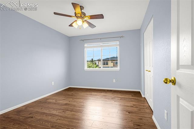11045 Falling Star Road Fountain, CO 80817 - Photo 19 of 39 Spare room with baseboards, a ceiling fan, and dark wood-style floors