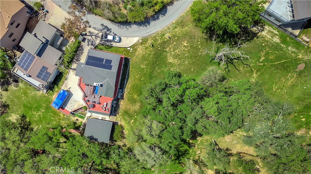an aerial view of a house with swimming pool and garden