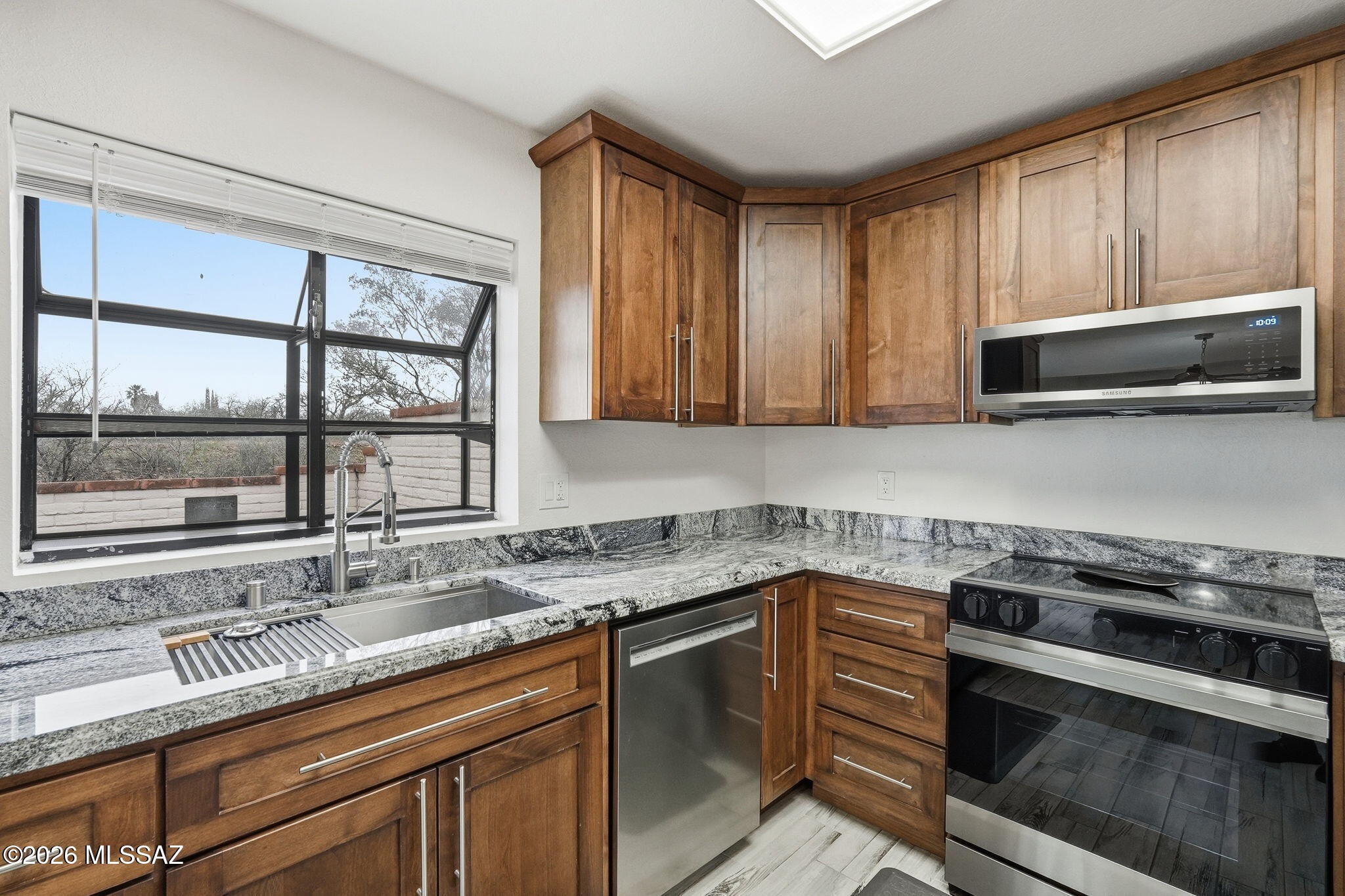 1183 Circulo Canario Rio Rico, AZ 85648 - Photo 7 of 31 a kitchen with stainless steel appliances granite countertop a sink a stove and a microwave