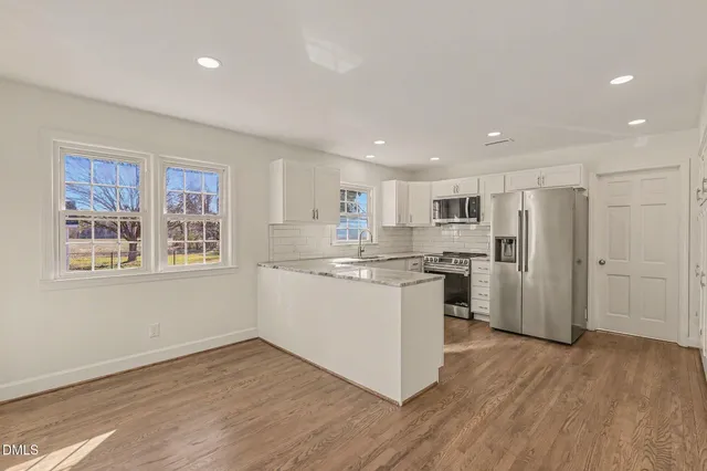 a kitchen with a refrigerator and white cabinets
