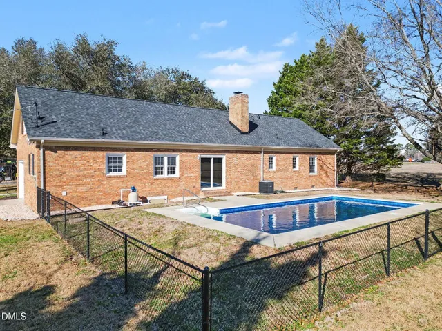 a view of house with swimming pool and sitting area