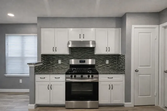 a kitchen with stainless steel appliances white cabinets and stove
