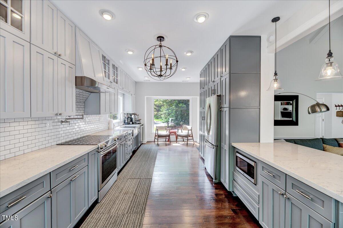 11313 Rumshill Road Raleigh, NC 27614 - Photo 15 of 55 a large kitchen with stainless steel appliances granite countertop a lot of counter space and wooden floors