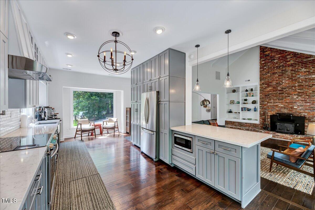 11313 Rumshill Road Raleigh, NC 27614 - Photo 16 of 55 a open kitchen with stainless steel appliances granite countertop a stove refrigerator a dining table and chairs with wooden floor