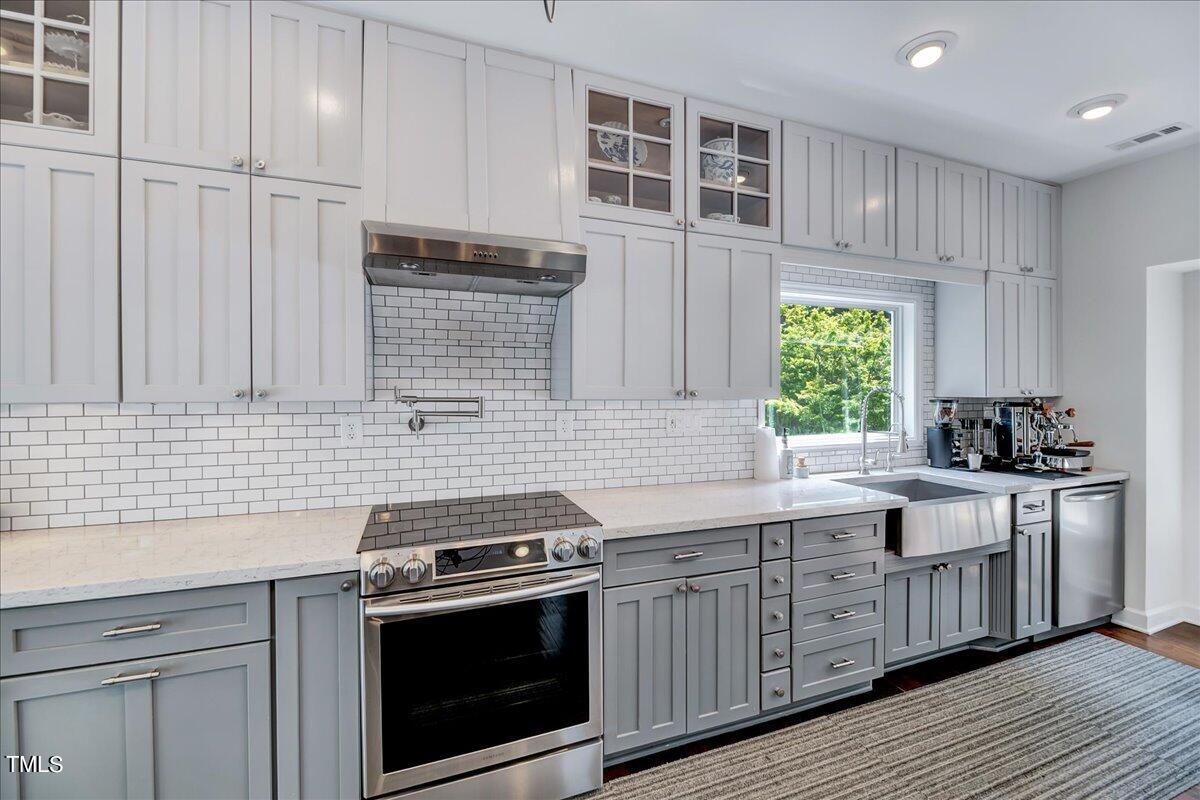 11313 Rumshill Road Raleigh, NC 27614 - Photo 17 of 55 a kitchen with stainless steel appliances granite countertop a stove a sink and a microwave