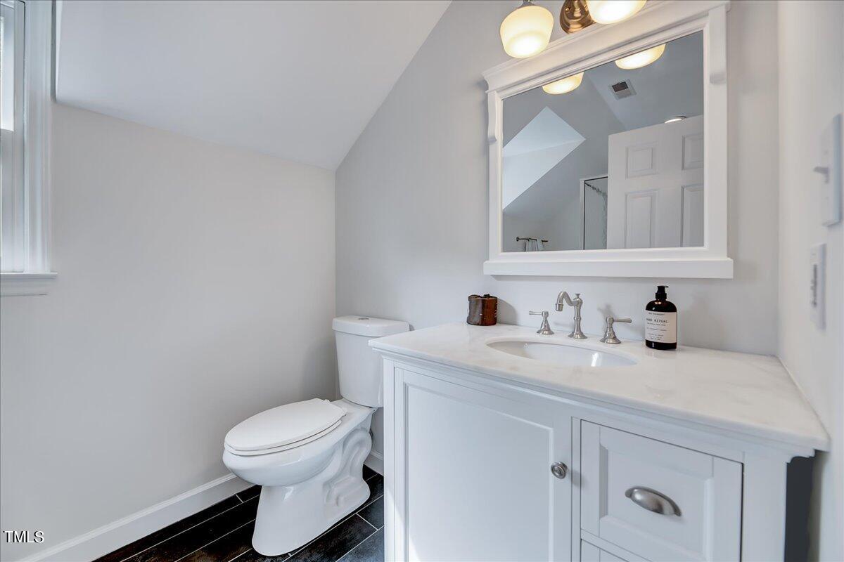 11313 Rumshill Road Raleigh, NC 27614 - Photo 42 of 55 a bathroom with a granite countertop toilet sink mirror and vanity