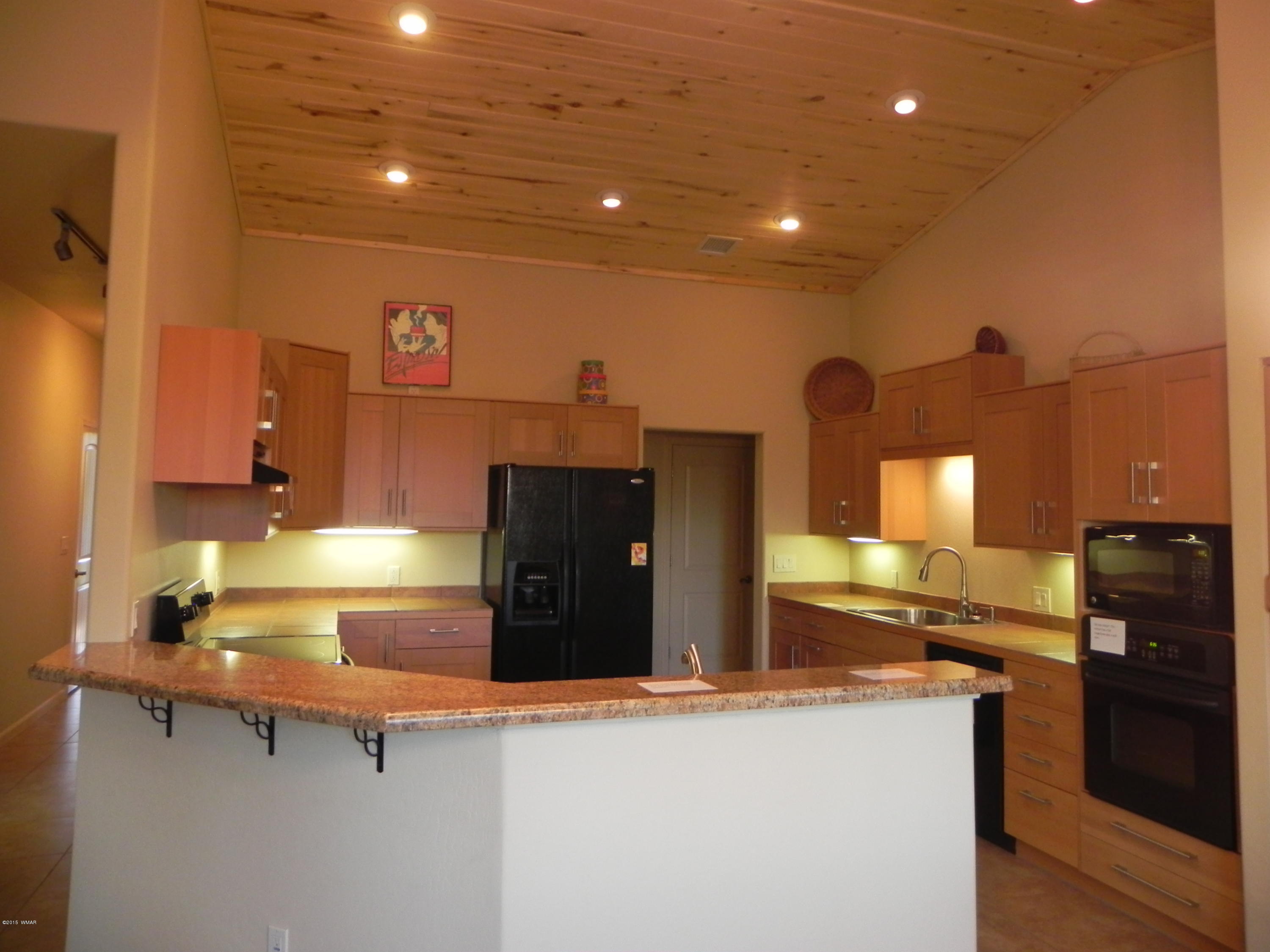 5975 Luminary Way Lakeside, AZ 85929 - Photo 17 of 44 a kitchen with stainless steel appliances granite countertop a sink and a refrigerator