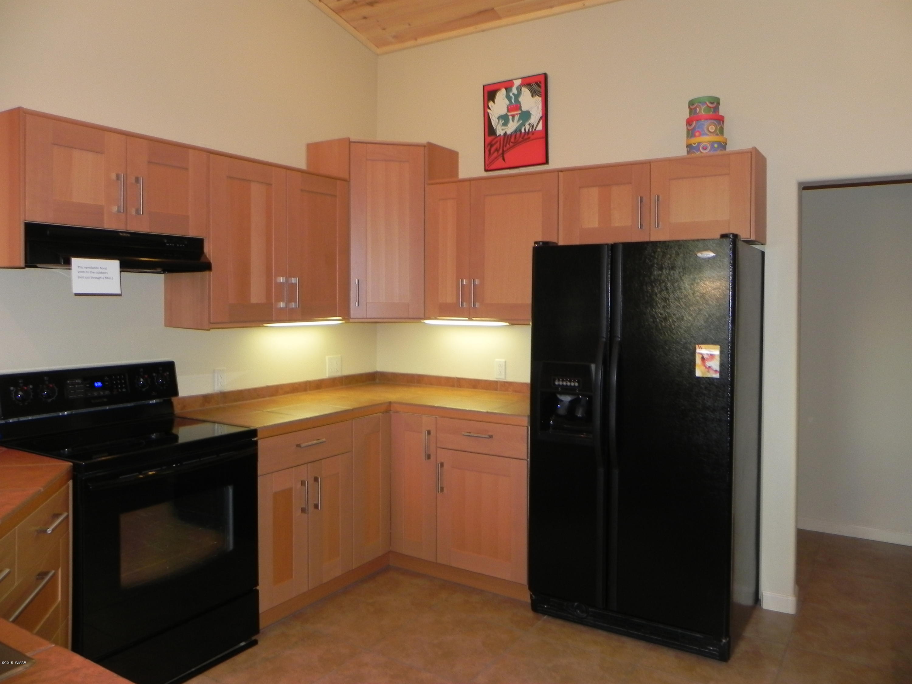 5975 Luminary Way Lakeside, AZ 85929 - Photo 20 of 44 a kitchen with a refrigerator and cabinets