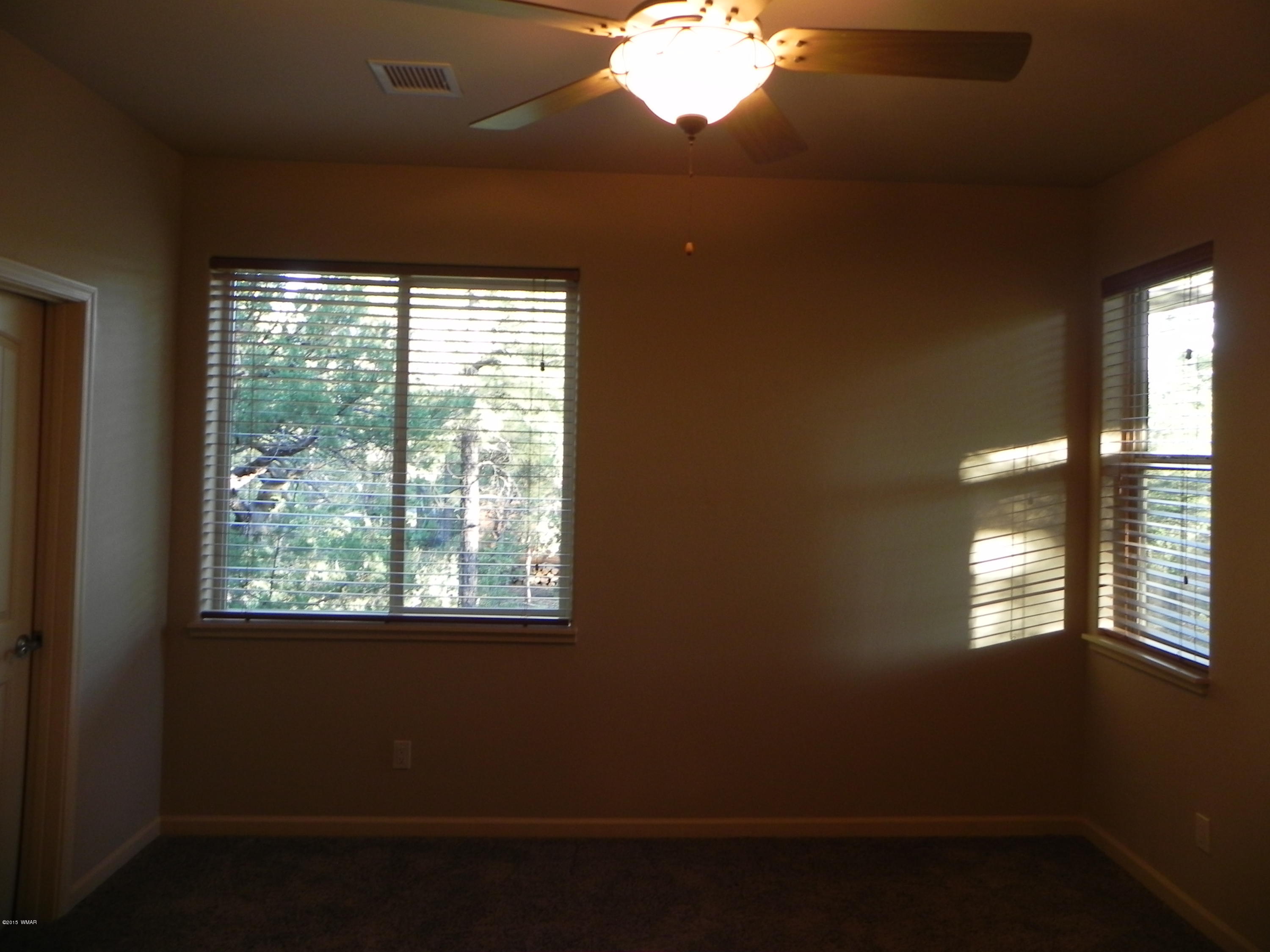 5975 Luminary Way Lakeside, AZ 85929 - Photo 22 of 44 a view of an empty room with wooden floor and a window
