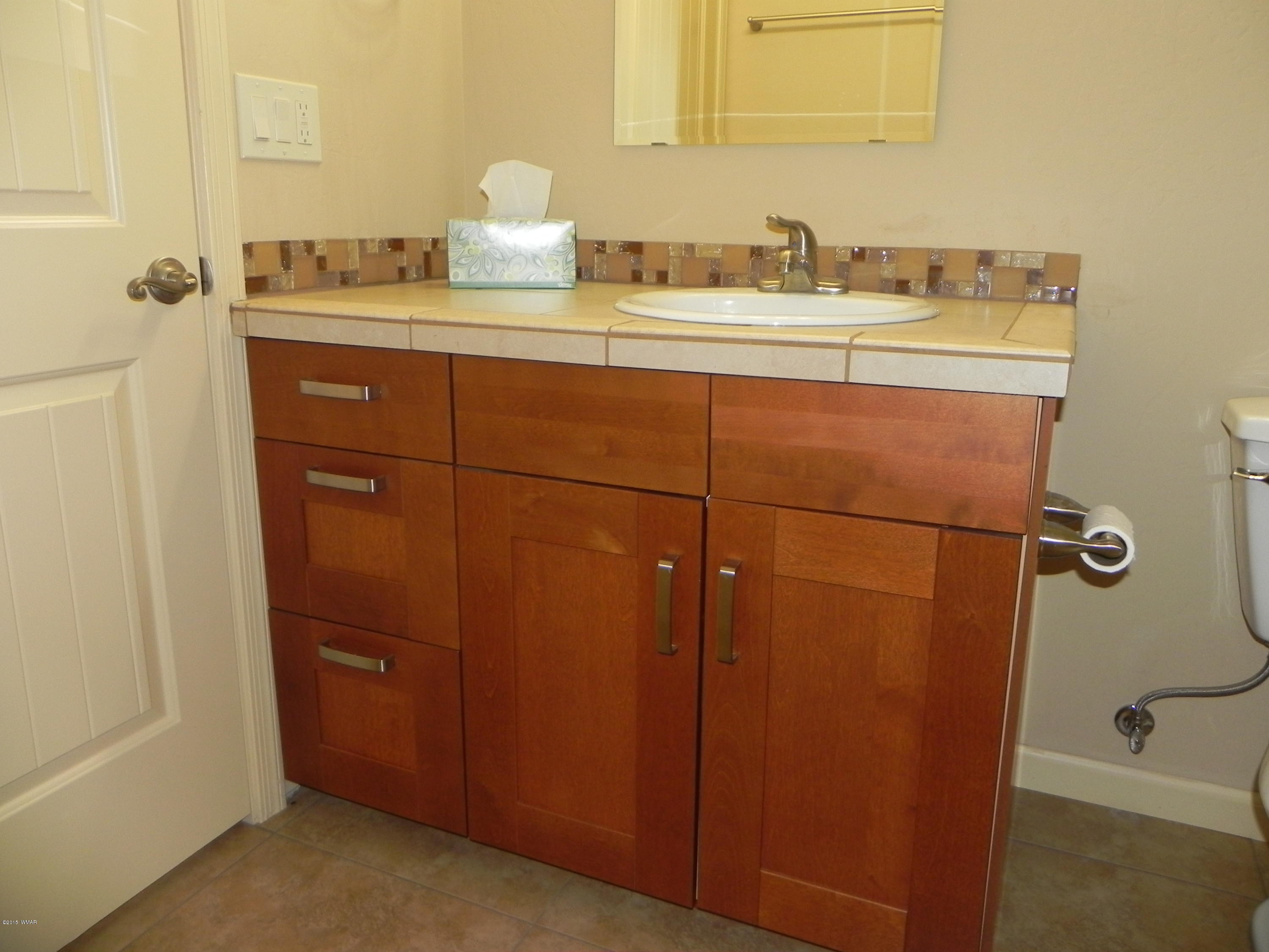 5975 Luminary Way Lakeside, AZ 85929 - Photo 26 of 44 a bathroom with a granite countertop sink and a mirror