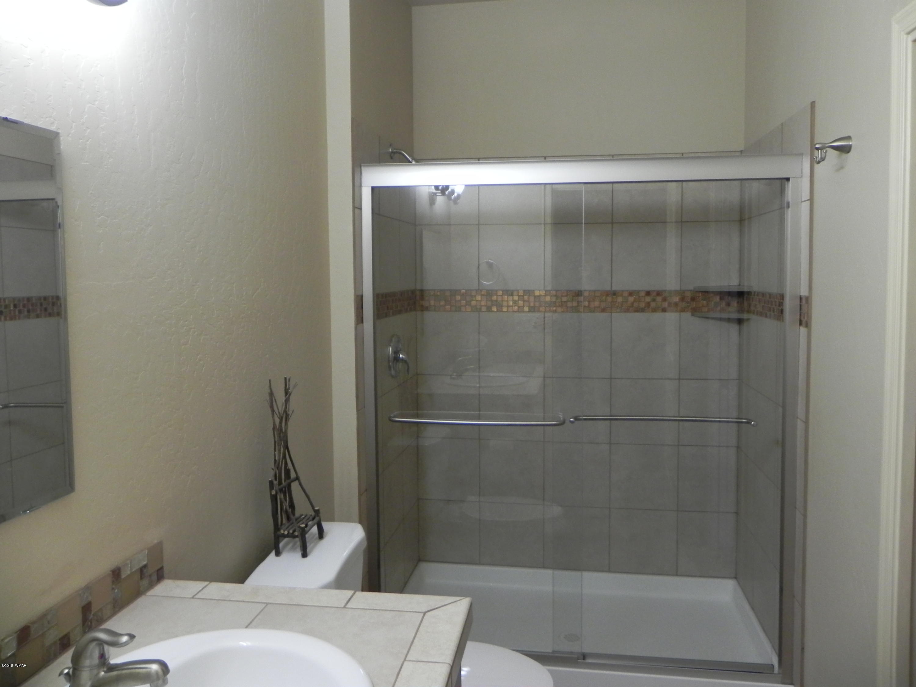 5975 Luminary Way Lakeside, AZ 85929 - Photo 27 of 44 a bathroom with a shower and toilet