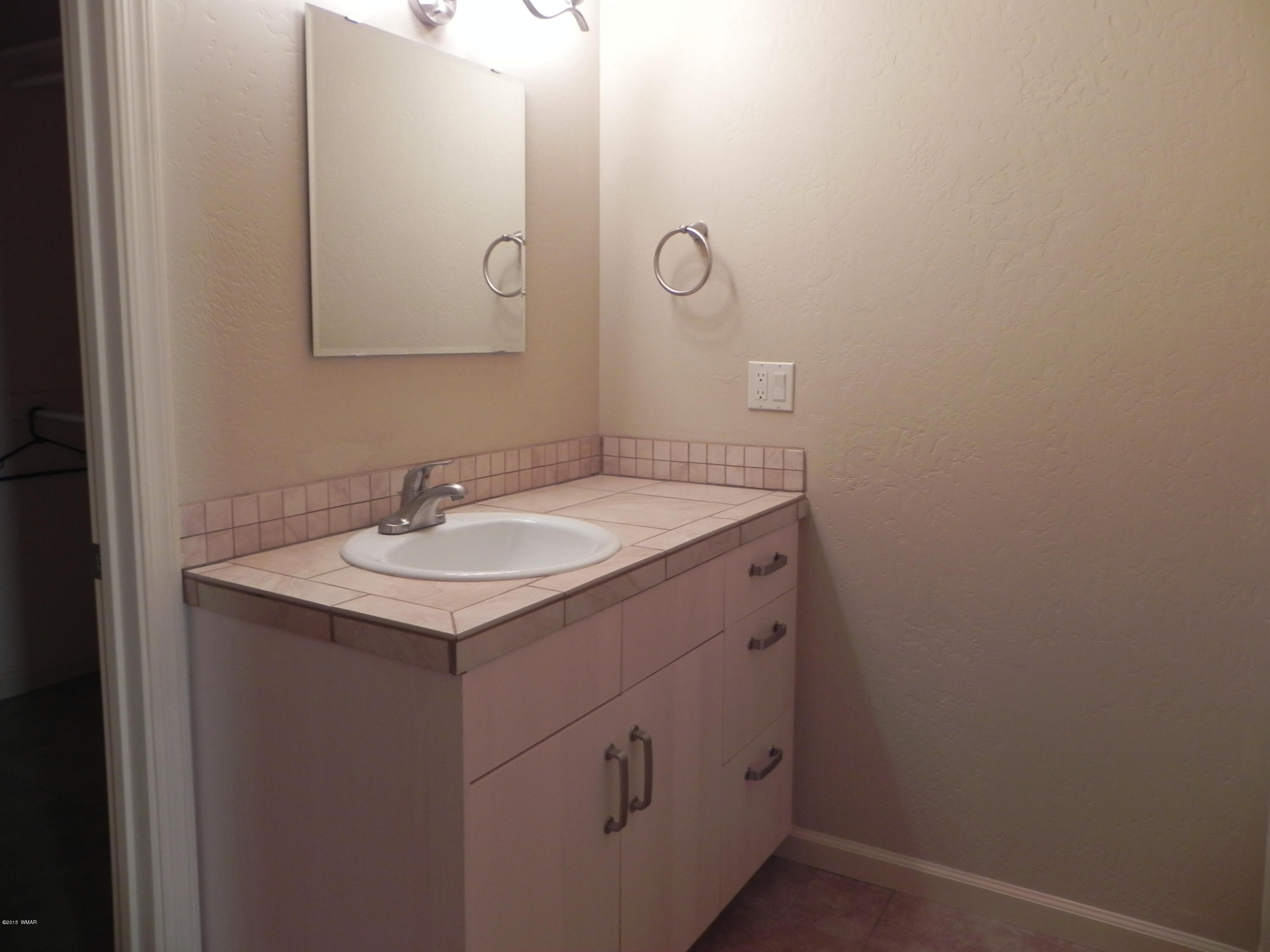 5975 Luminary Way Lakeside, AZ 85929 - Photo 37 of 44 a bathroom with a sink and mirror