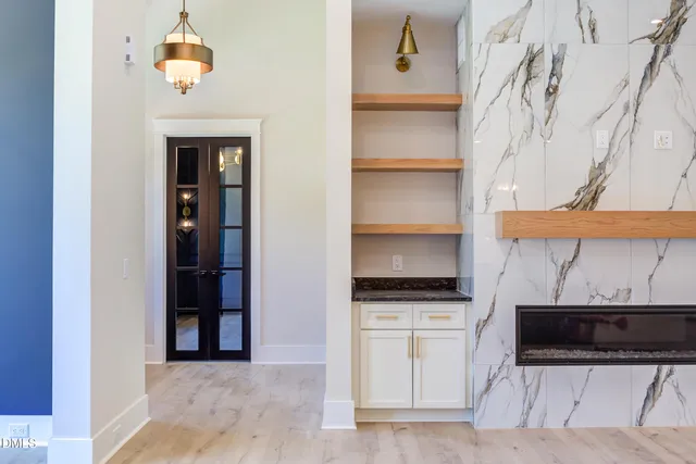 a view of an empty room with a window and cabinet