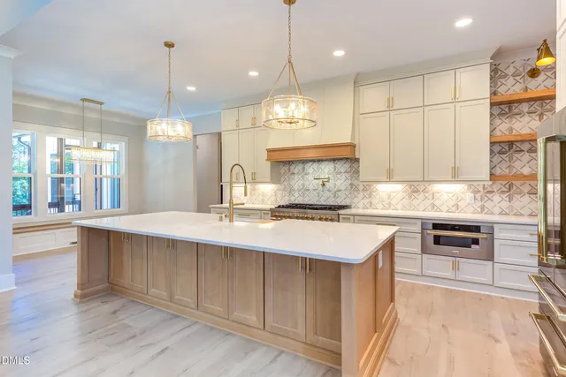 a large kitchen with kitchen island a sink stainless steel appliances and cabinets