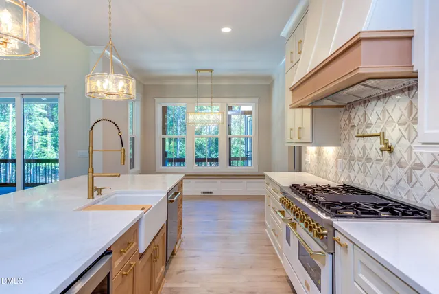 a kitchen with a stove a sink and a large window