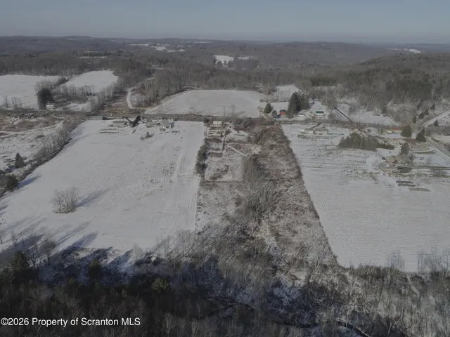 a view of a dry yard with wooden fence