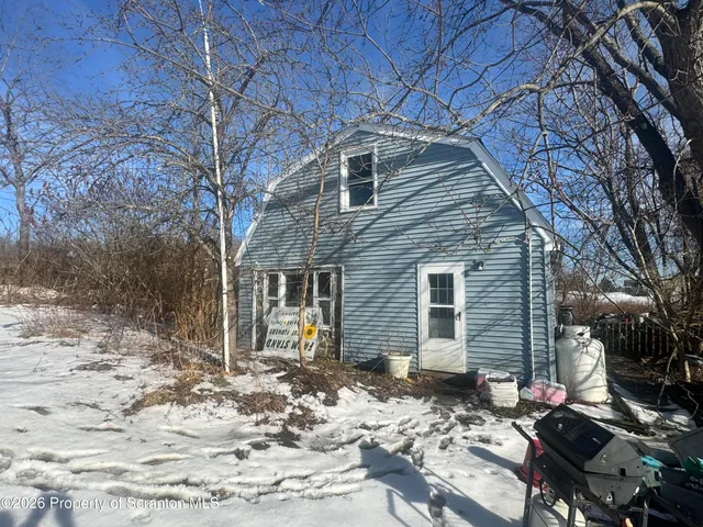 a backyard of a house with large trees and covered by side of it