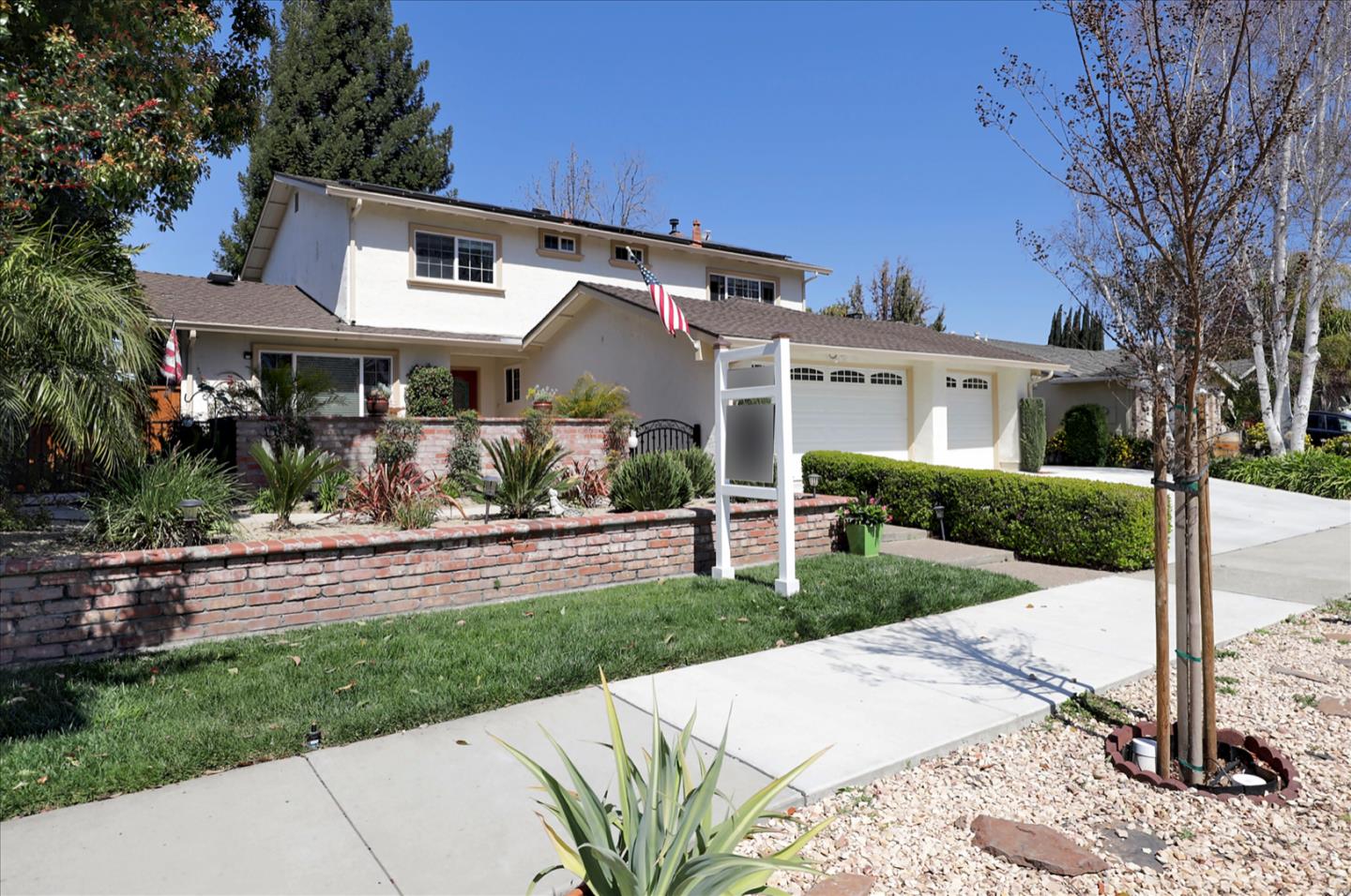731 West 9th Street Gilroy, CA 95020 - Photo 2 of 37 a view of a white house with a yard and table and chairs under an umbrella