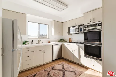 a kitchen with white cabinets and white appliances