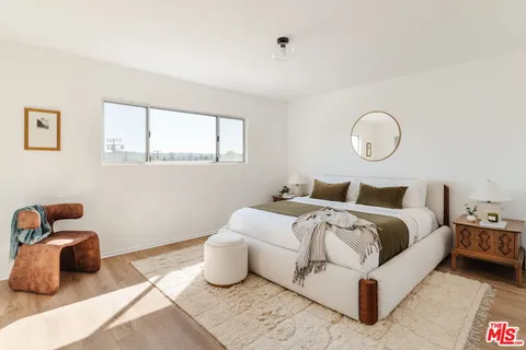 a bedroom with a bed and painting on the wall