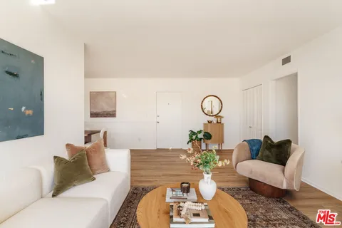 a living room with furniture a table and wooden floor