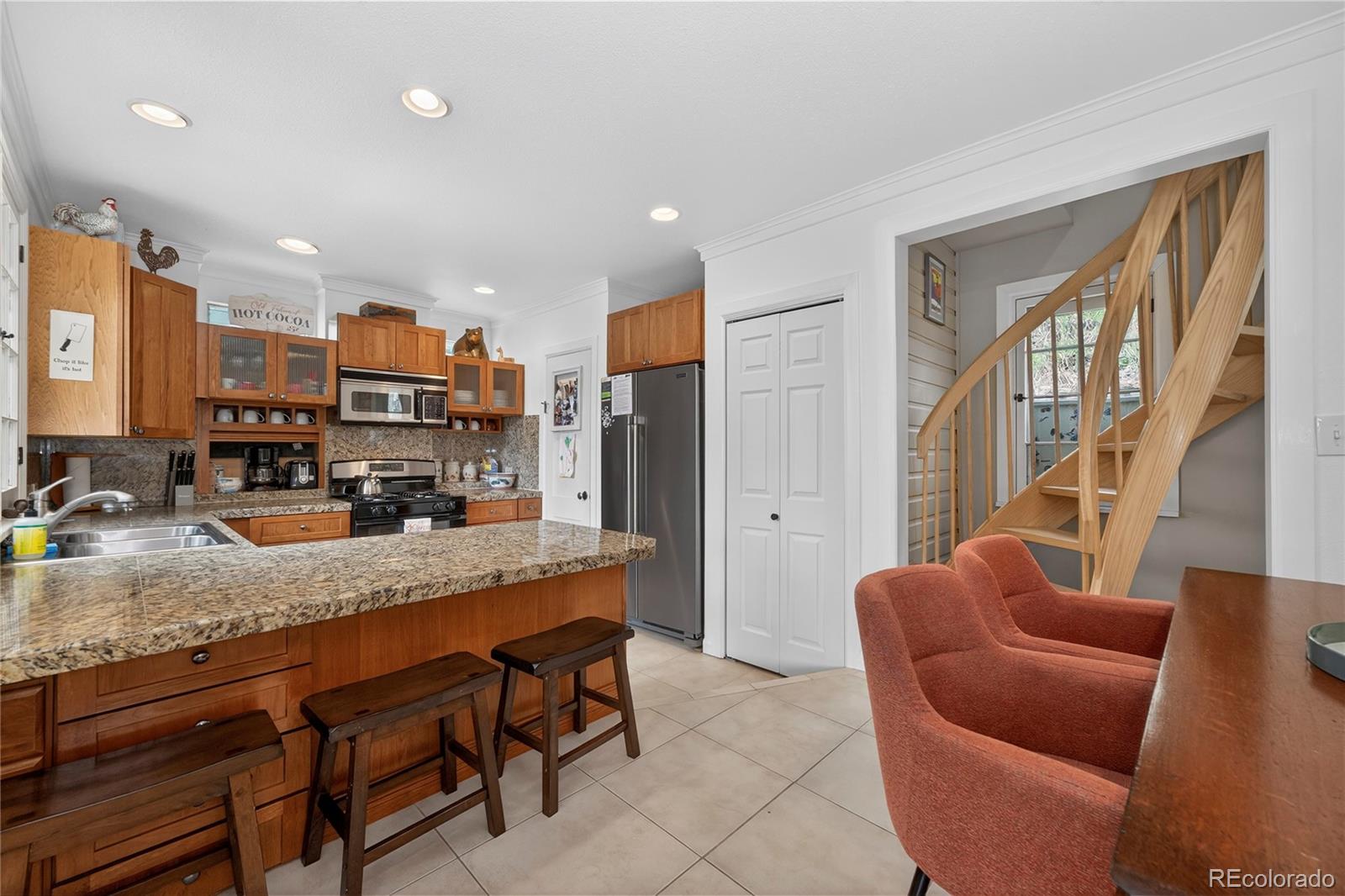 327 Vasquez Road, Unit E1 Winter Park, CO 80482 - Photo 36 of 43 a kitchen with stainless steel appliances granite countertop a table chairs in it and a refrigerator