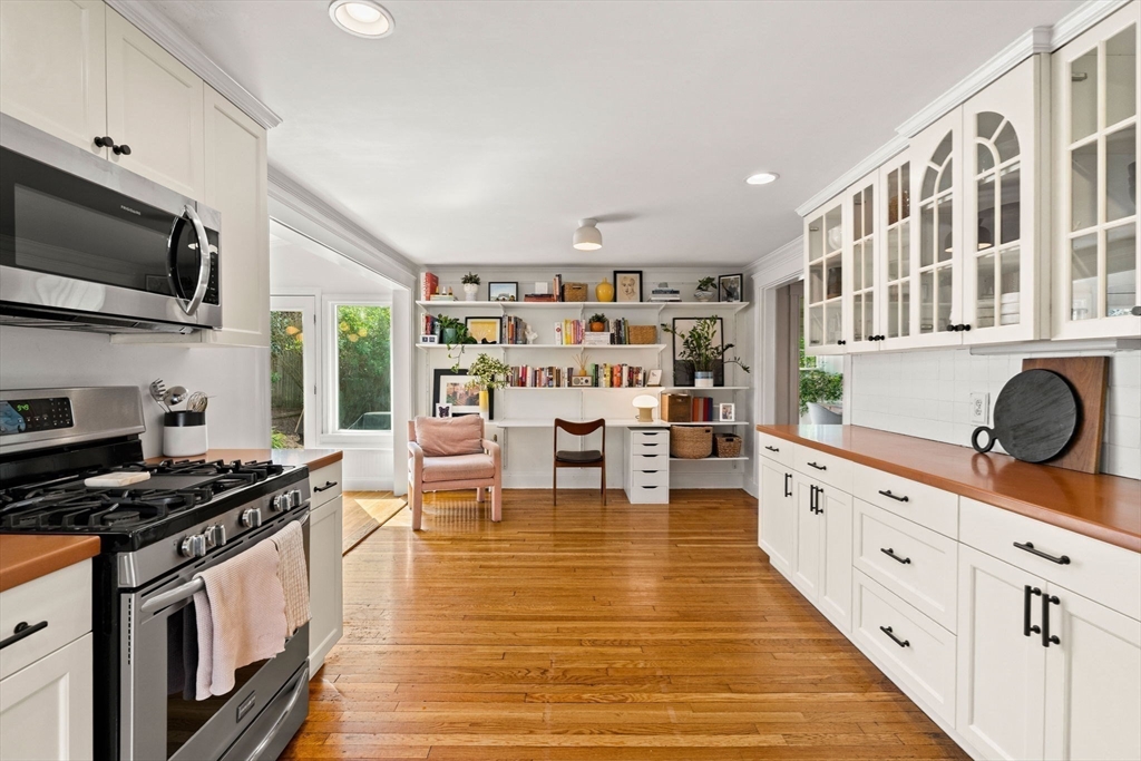 34 Avalon Road Milton, MA 02186 - Photo 18 of 42 a kitchen with stainless steel appliances kitchen island granite countertop a stove top oven a sink a dining table and chairs with wooden floor