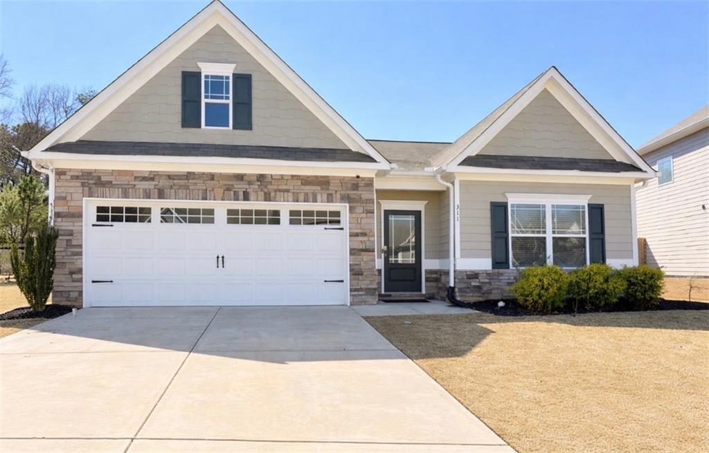 311 Eagles Bluff Way Hoschton, GA 30548 - Photo 1 of 1 a front view of a house with a yard and garage