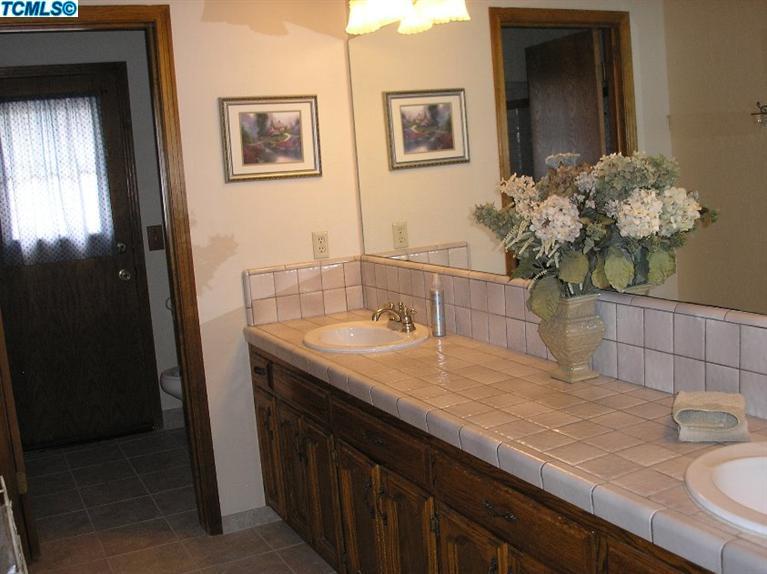 122 South Anderson Road Exeter, CA 93221 - Photo 15 of 26 a bathroom with a granite countertop sink a large mirror and vanity