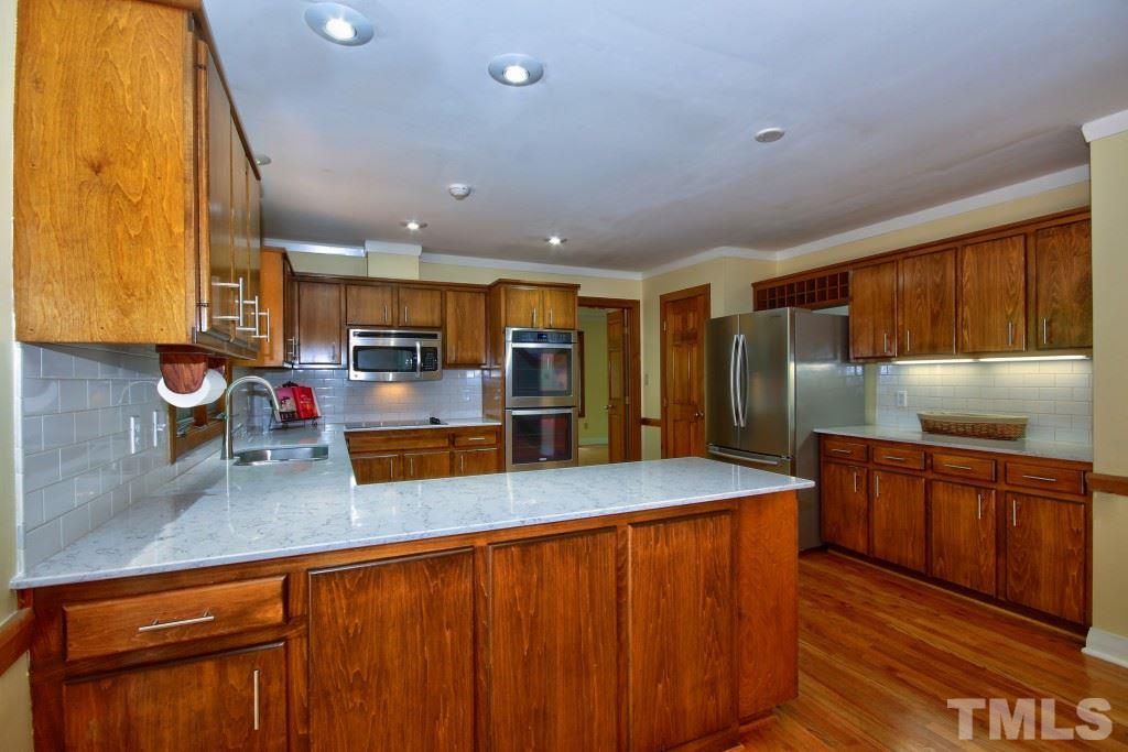 10008 Old Warden Road Raleigh, NC 27615 - Photo 3 of 24 a kitchen with stainless steel appliances granite countertop a sink a stove and a refrigerator