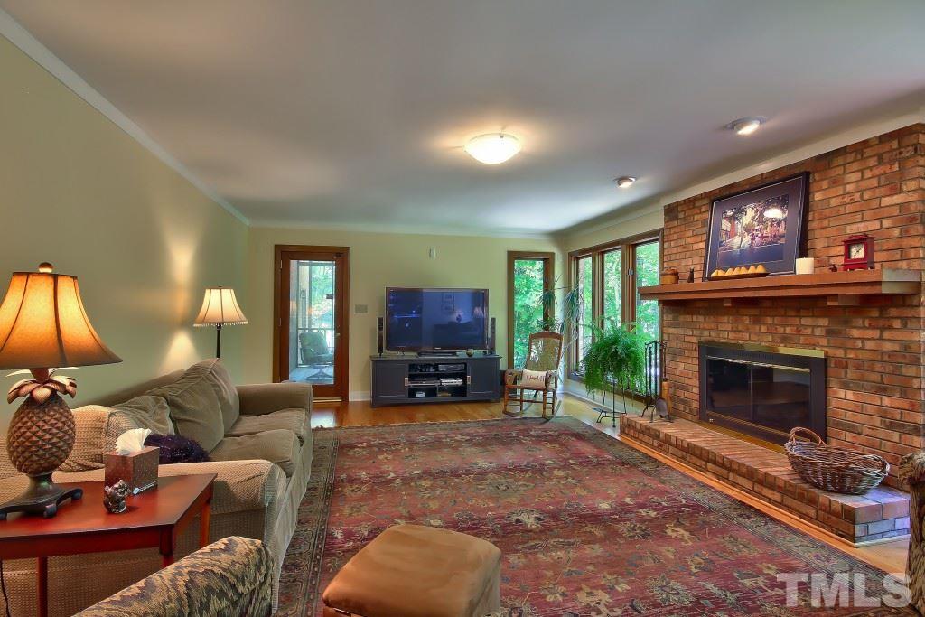10008 Old Warden Road Raleigh, NC 27615 - Photo 7 of 24 a living room with furniture a fireplace and a flat screen tv