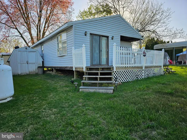 a backyard of a house with table and chairs and potted plants