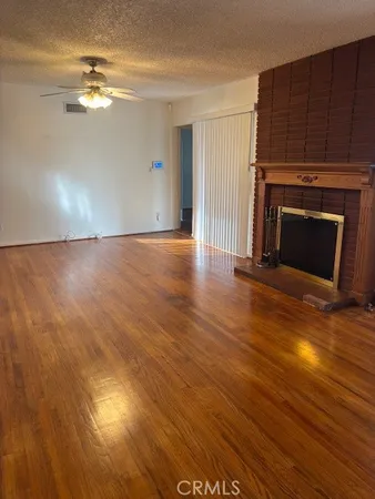 a view of a livingroom with wooden floor and a fireplace