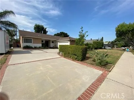 a view of a house with a yard and potted plants