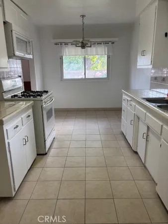 a kitchen with a sink a stove and cabinets