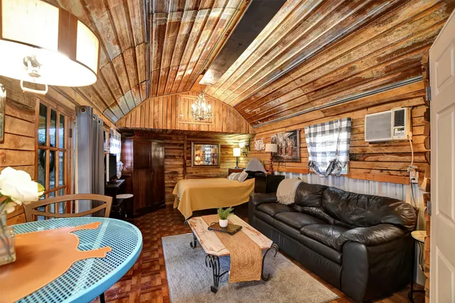 a room with furniture a flat screen tv and kitchen view