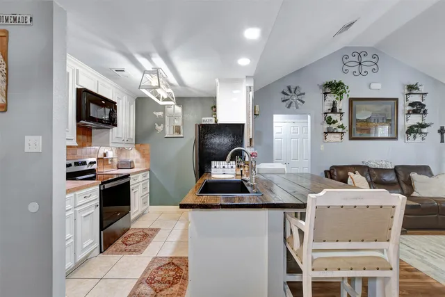 a kitchen with stainless steel appliances a stove a sink a microwave a refrigerator and cabinets