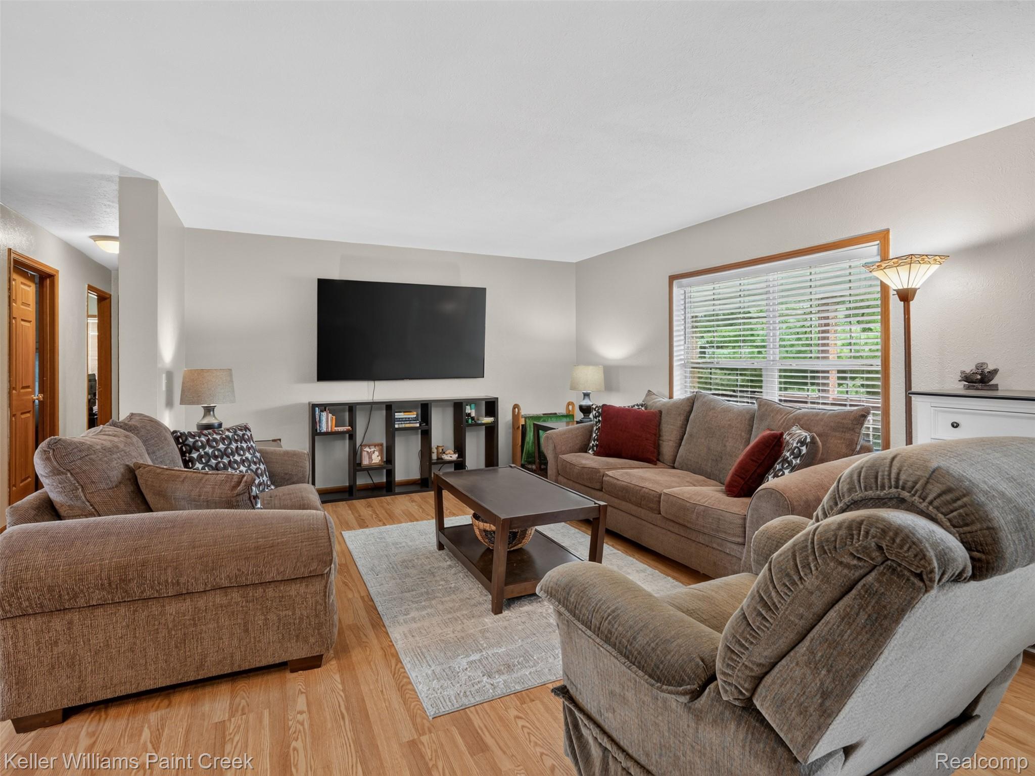 533 White Road Gladwin, MI 48624 - Photo 14 of 69 Hardwood-finish flooring, a large window, a ceiling fan with integrated lighting, and neutral wall tones