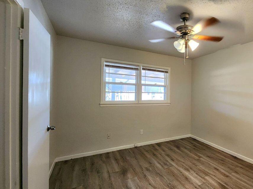 4401 31st Street Lubbock, TX 79410 - Photo 15 of 21 a view of an empty room with a window and wooden floor