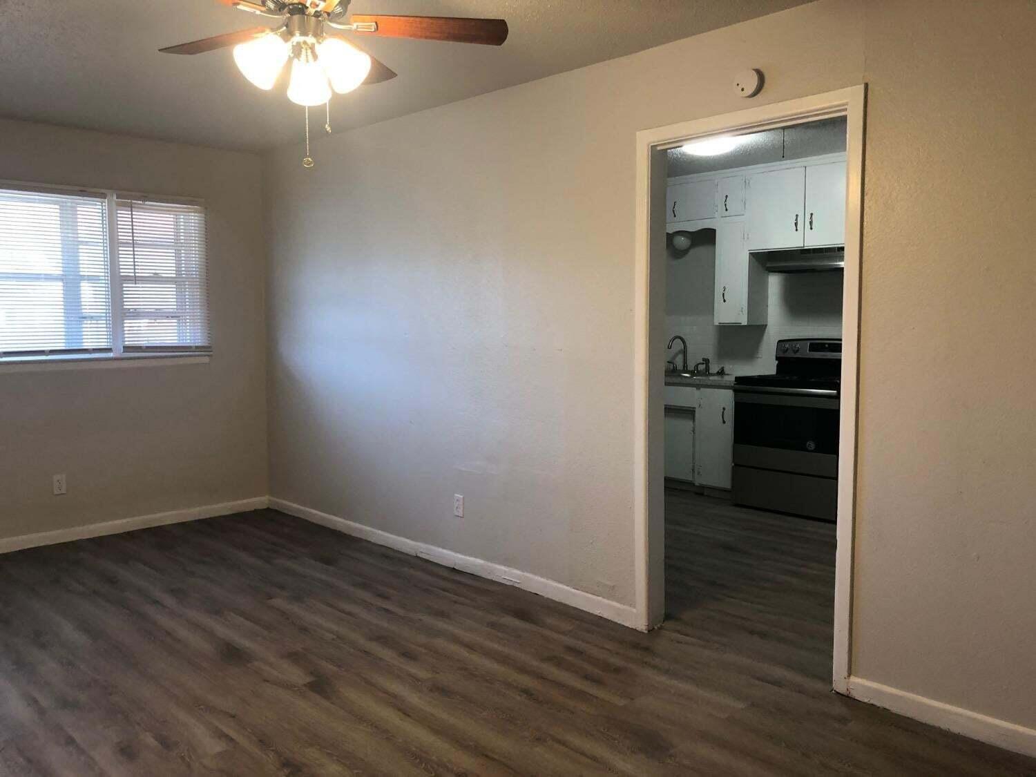 4401 31st Street Lubbock, TX 79410 - Photo 4 of 21 an empty room with wooden floor and cabinet