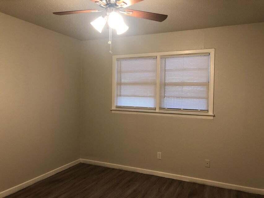4401 31st Street Lubbock, TX 79410 - Photo 6 of 21 a view of an empty room with wooden floor and a window
